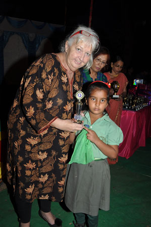 Ms. Jane Bentlay awarding a student for 100% attendance